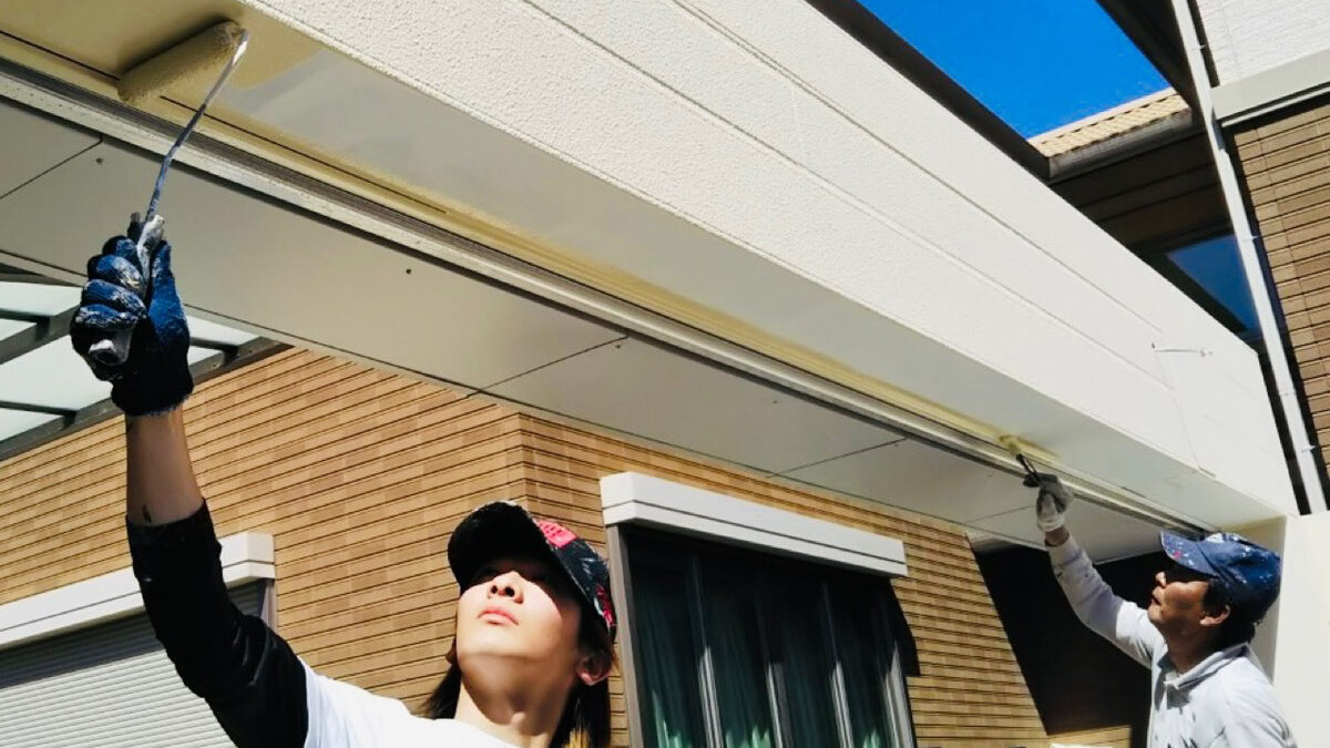 明石市・神戸市で外壁塗装を行う徳秀塗装の親子職人。一級塗装技能士の父と品質管理担当の息子が、阿吽の呼吸で丁寧に軒天を塗装している様子