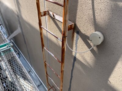 明石市での施工現場。屋上のタラップ（梯子）に発生した錆を確認しました。放置すると腐食が進んで折れる危険があるため、外壁塗装と合わせた補修が不可欠です。