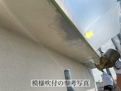 外壁の部分修理において、既存の壁の凹凸模様と違和感が出ないよう、職人が専用のガンを使って丁寧に塗料を吹き付け、模様を再現している様子。