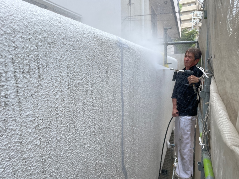 外壁塗装を10年以上長持ちさせるための大前提となる高圧洗浄作業。単に表面を綺麗にするだけでなく、古い塗膜やコケを根こそぎ洗い流し、新しい塗料が外壁にしっかりと密着する完璧な下地を作っています。