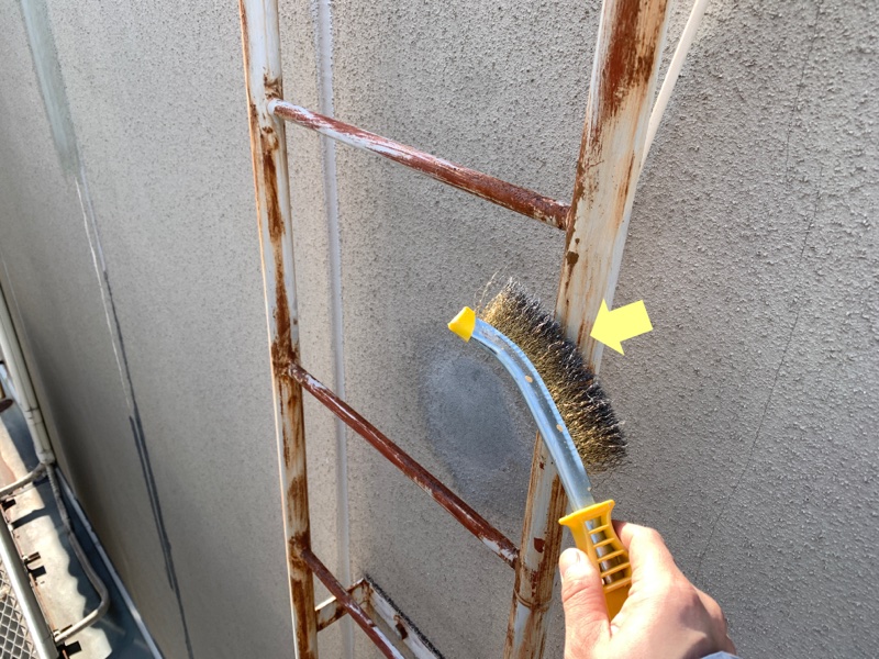 金ブラシを使ったケレン作業（錆落とし）。錆の上から塗ってもすぐに剥がれてしまうため、手作業で根気よく錆を削り落とし、下地を整えます。