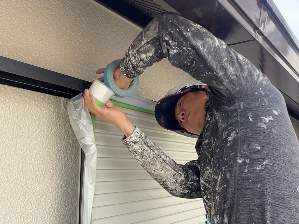 夏場の息苦しさを軽減するため、養生ビニール(マスカー)に手作業で養生している職人の様子。