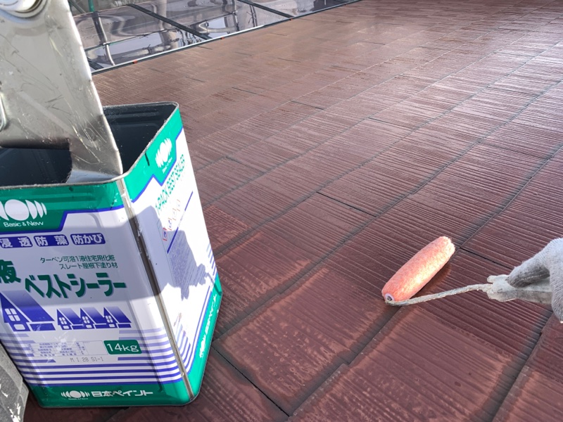 洗浄後のキレイになった屋根に、塗料の接着剤の役割を果たす「下塗り」をたっぷりと塗り込んでいる様子。